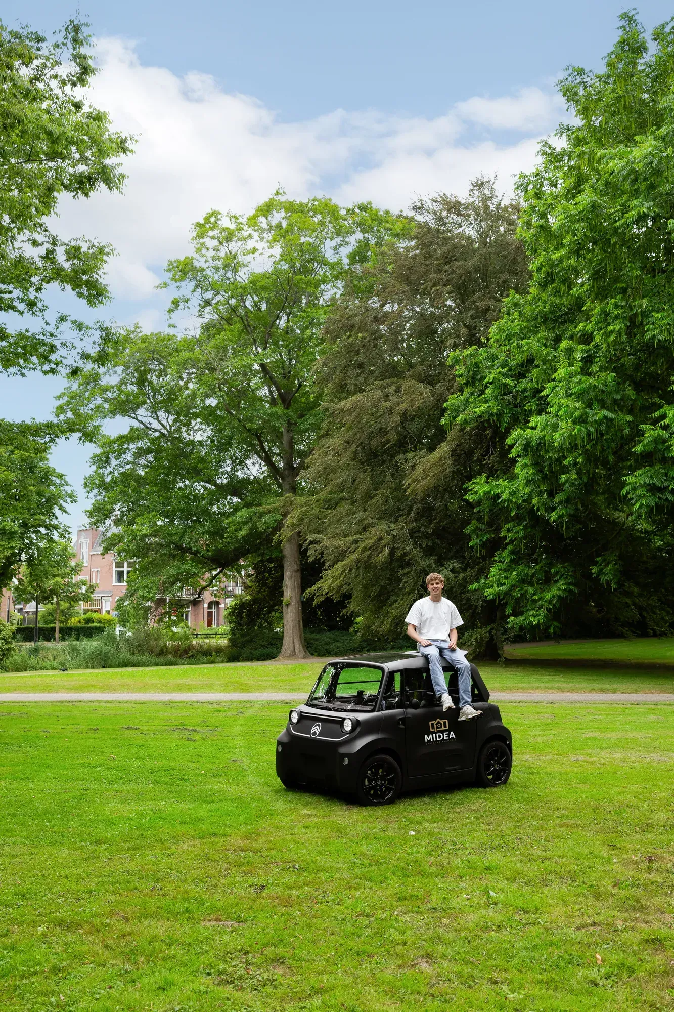 Adviseur van MV Adviseurs op het elektrische wagentje van het bedrijf, in een park