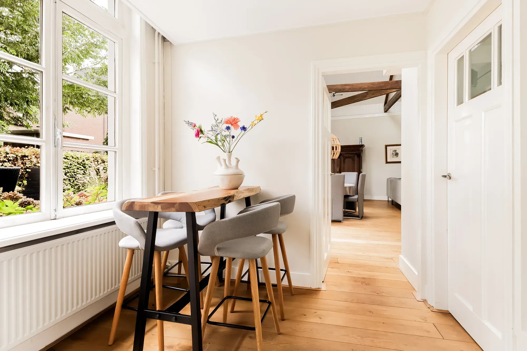 Eettafel bij het raam in een lichte woonkamer