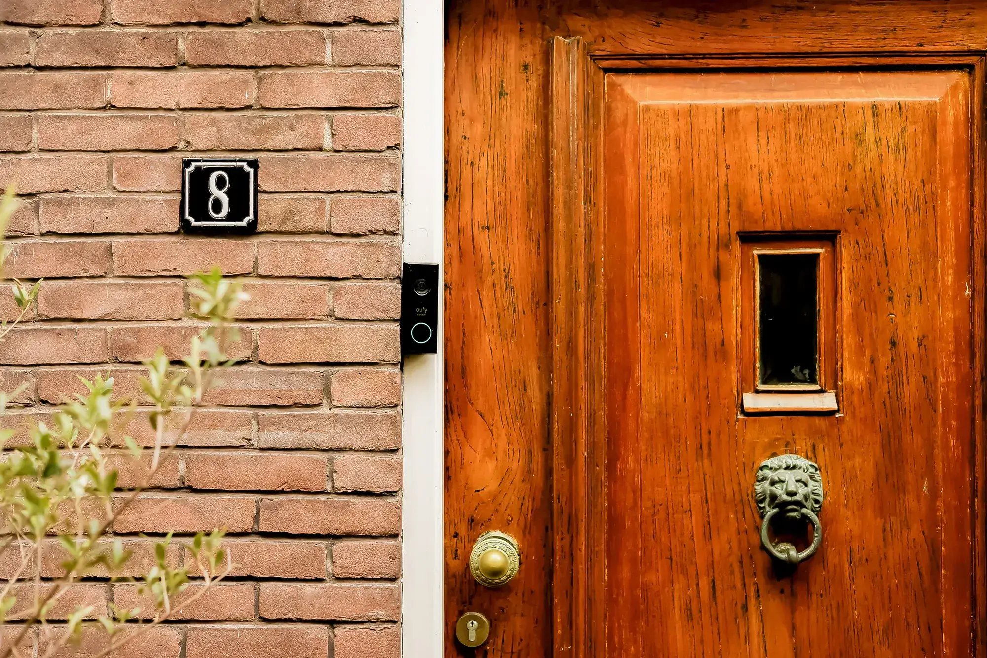 Bakstenen gevel en voordeur van een vooroorlogse woning, close-up van het metselwerk