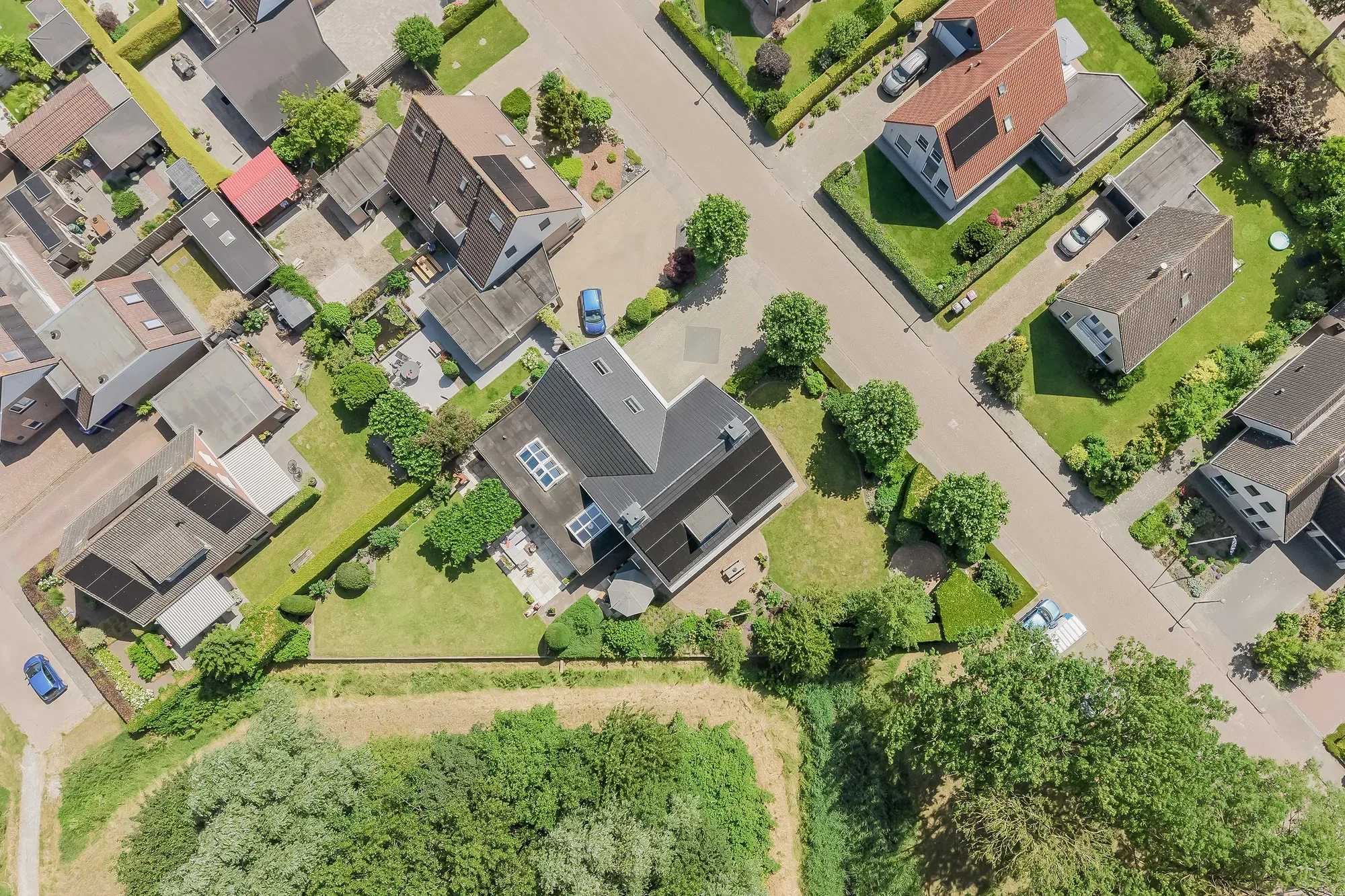 Luchtfoto van een naoorlogse woonwijk met zonnepanelen op de daken