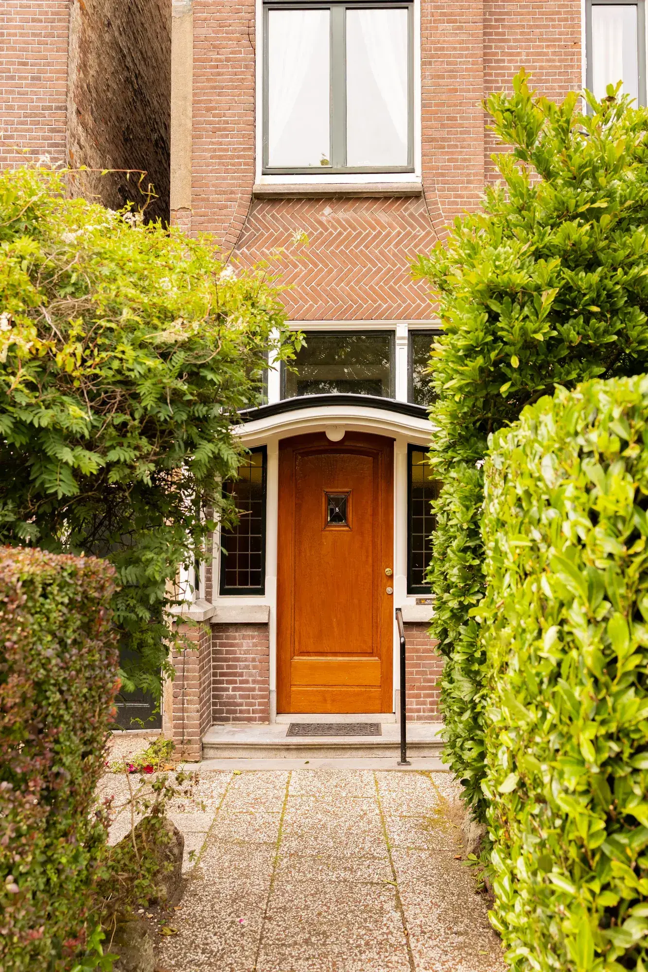 Klassieke voordeur van een vooroorlogse woning met bakstenen gevel
